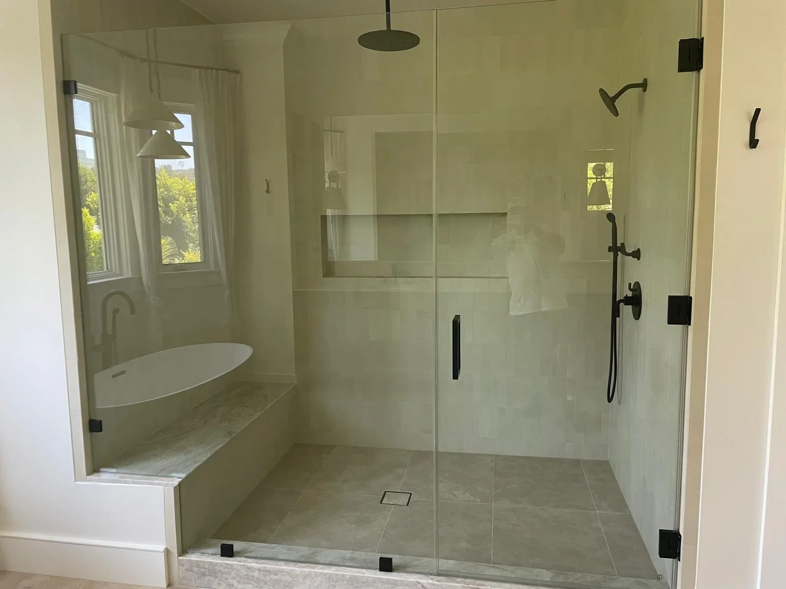Modern master bathroom with frameless glass shower, tile flooring, and soaking tub