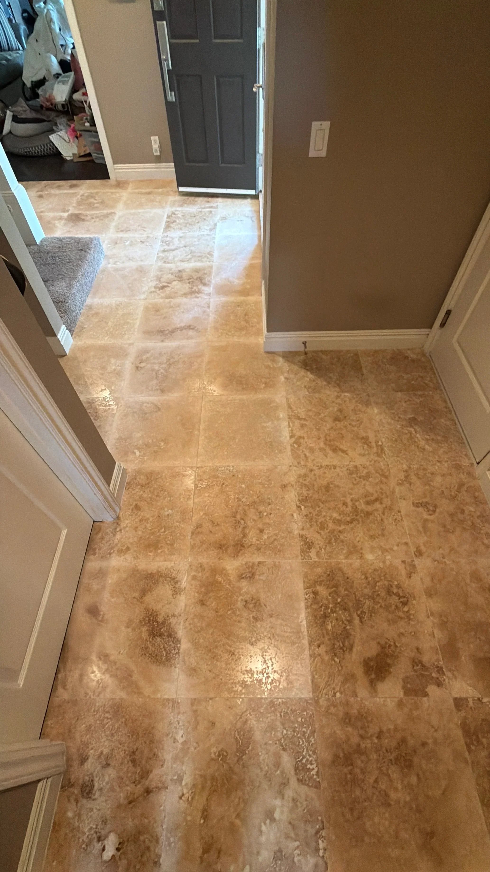 Travertine tile entryway with natural stone patterns and professional grout lines