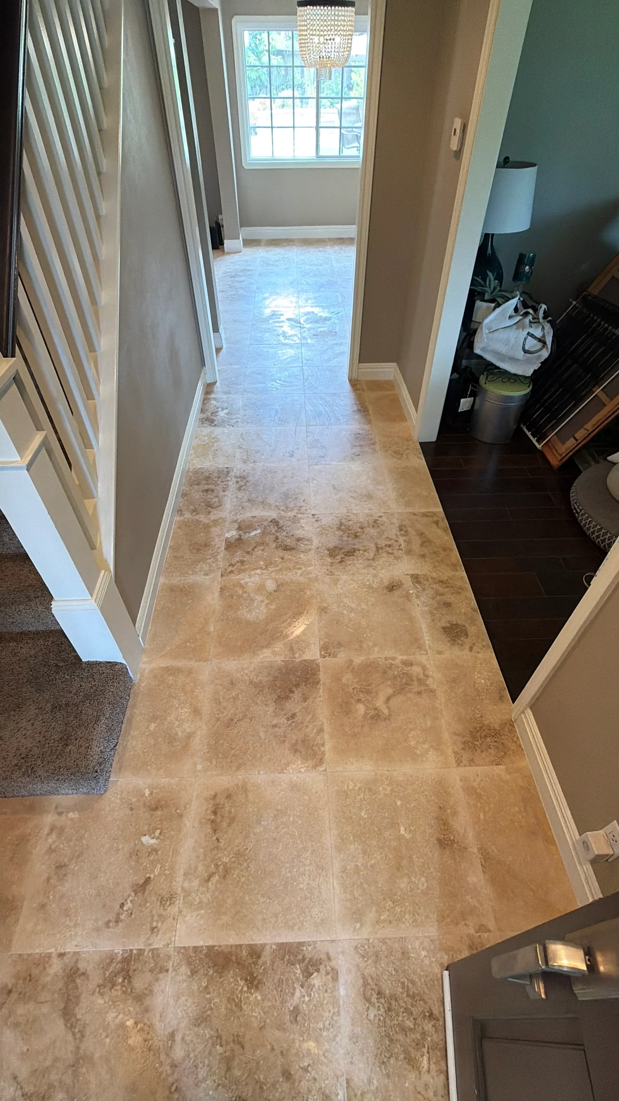 Travertine tile hallway with large window and neutral wall colors
