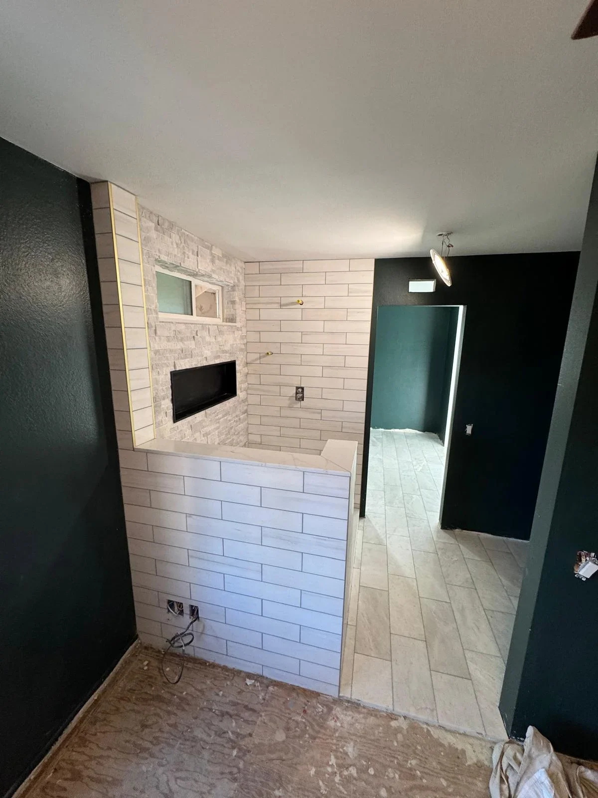 Modern bathroom with subway tile walls, stone flooring, and frameless glass shower enclosure
