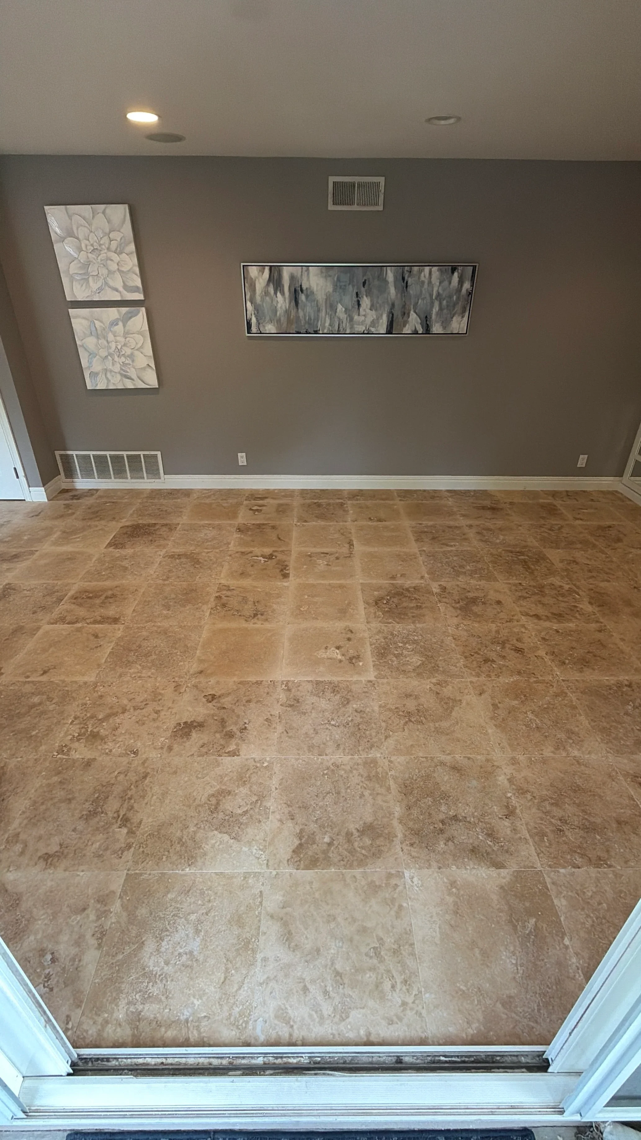 Newly installed travertine tile floor with warm beige tones and natural stone patterns
