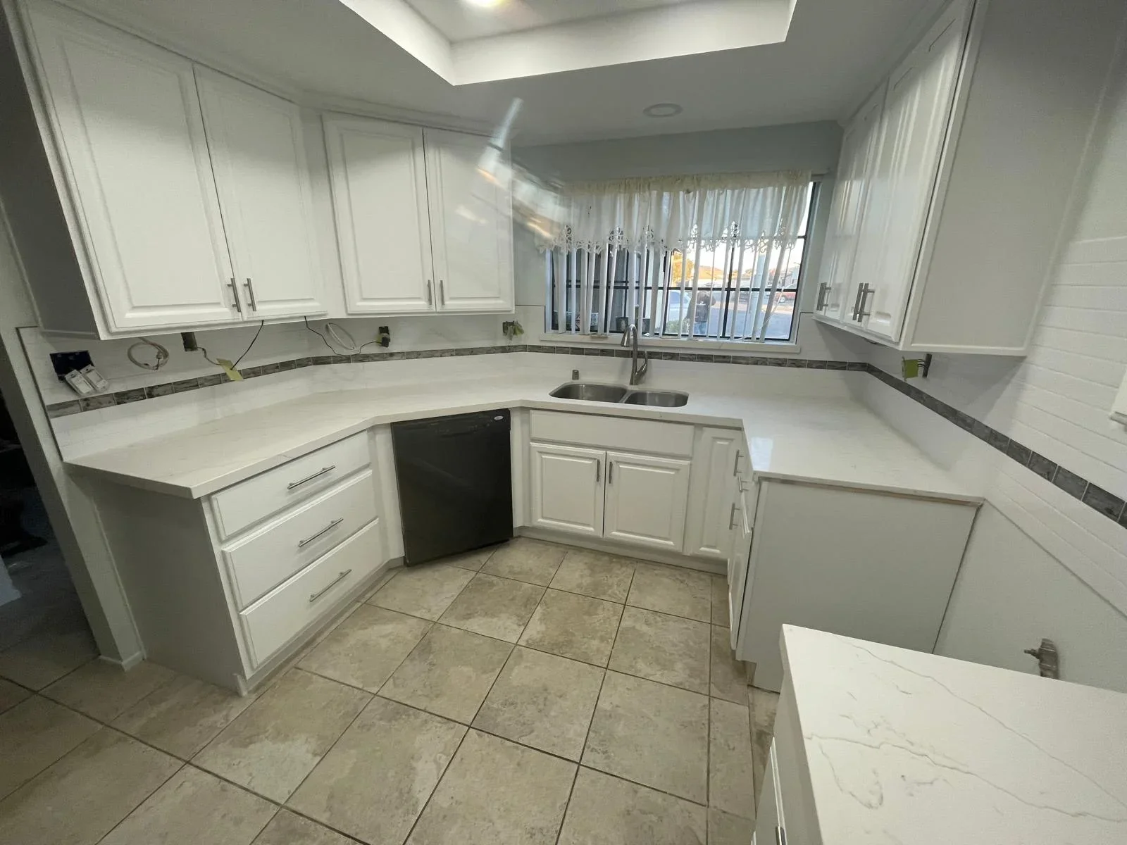 Kitchen with newly installed large-format ceramic tile flooring in neutral earth tones