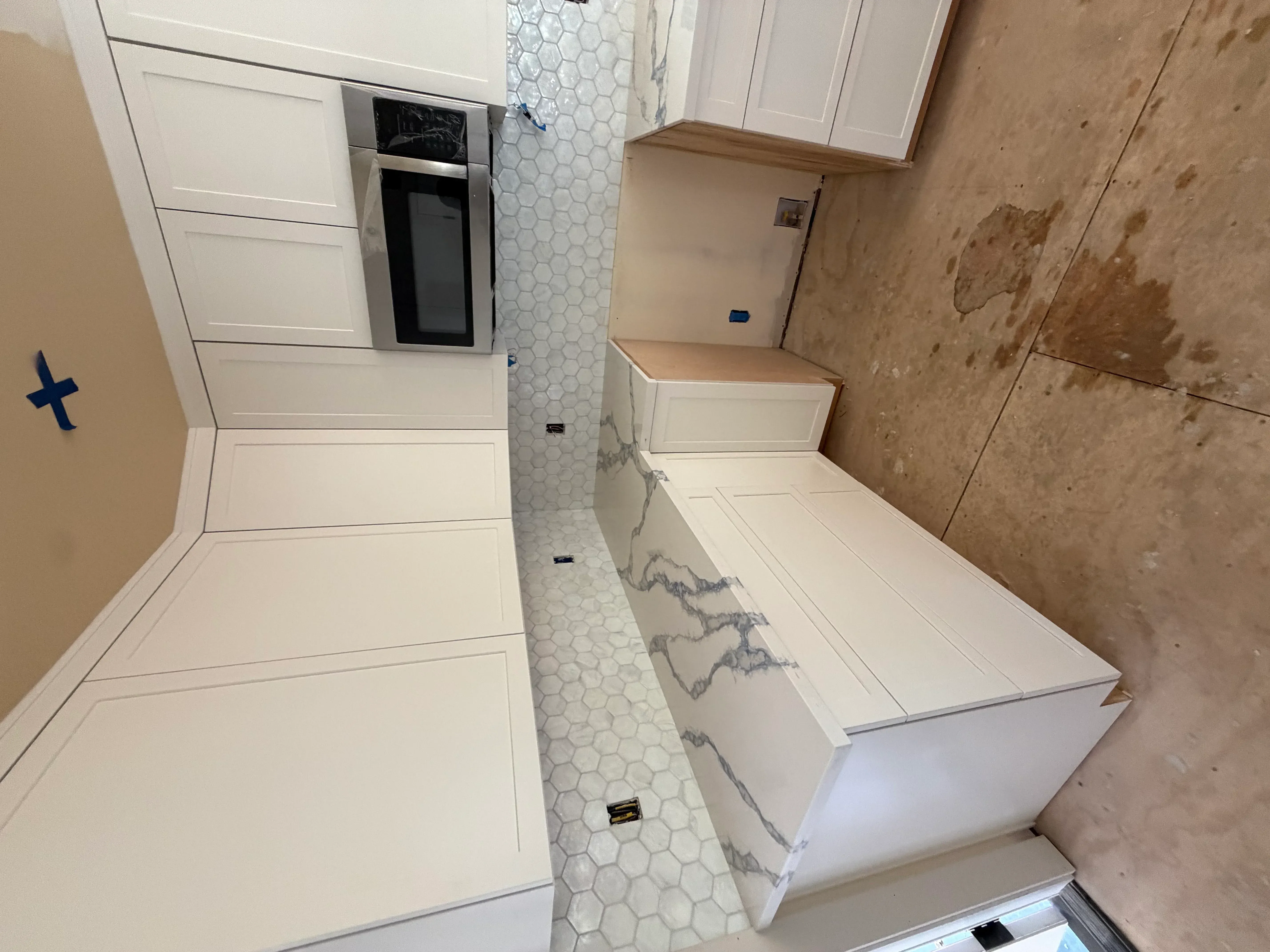 Newly remodeled bathroom with white subway tiles, hexagonal floor mosaic, and marble accents